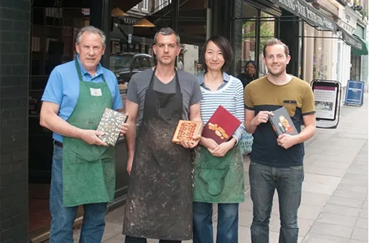 John Goss, Daniel Wray, Eri Funazaki and Luke Hornus outside the Shepherds shop, holding finished bindings