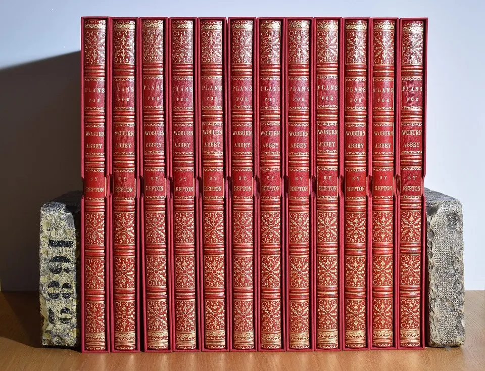 Twelve volumes of Repton's Plans for Woburn Abbey bound in red leather with gilt spines, standing in matching slipcases
